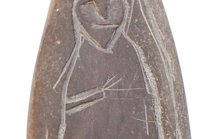 Каменный оселок с изображением человека